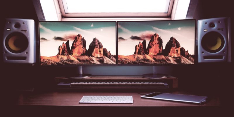 turned on two flat screen computer monitors with speakers